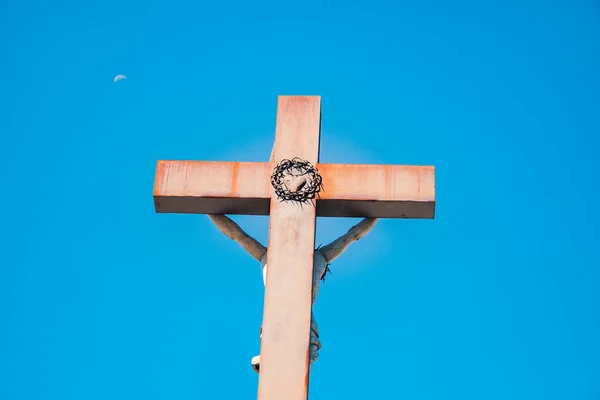 christian cross in front of the holy bible. christian cross with Jesus on the back, the moon in the sky in the background