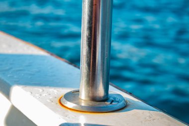 a metal boat on the pier. blue water on a background of the ship.