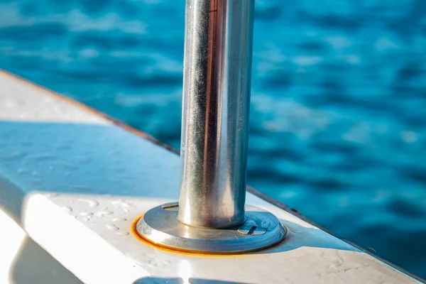 a metal boat on the pier. blue water on a background of the ship.