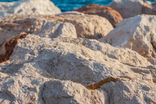 Güneşli yaz gününde kayalık sahilde taşlar.