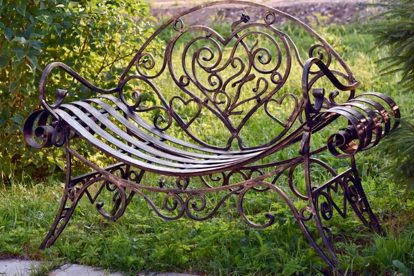 Heart-shaped forged metal lovers bench in the park — Stock Photo, Image