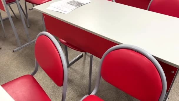 Empty school class with red chairs with papers on desks. video — Stock Video