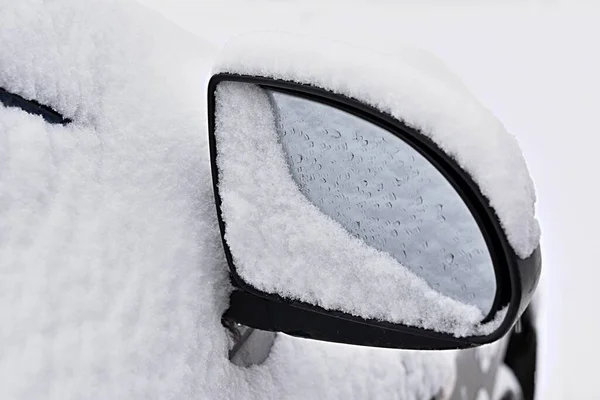 Car mirror covered with snow in droplets from melting snowflakes — Fotografia de Stock