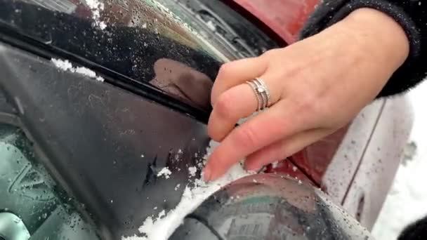 女手擦去汽车挡风玻璃庭院上的雪 — 图库视频影像