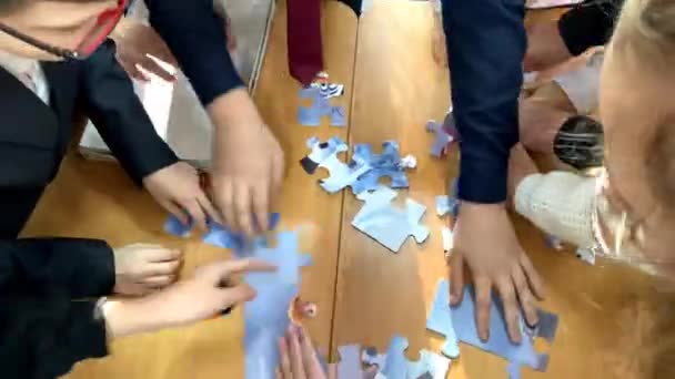 Les mains des enfants recueillant le puzzle à la vitesse. vacances éditoriales de la nouvelle année à l'école Penza Russie Décembre 2022 — Video