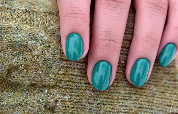 Hände Mit Smaragdgrüner Maniküre Liegen Auf Einem Gestrickten Hellgrünen Pullover — Stockfoto