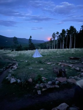 13 Temmuz 2020 'den kalma bir Buck Moon. Çimlerin üzerinde küçük bir çadır olan bir çayırın tepesinden. 2022 Yaz sezonunda Philmont Scout Çiftliğinde çekildi.
