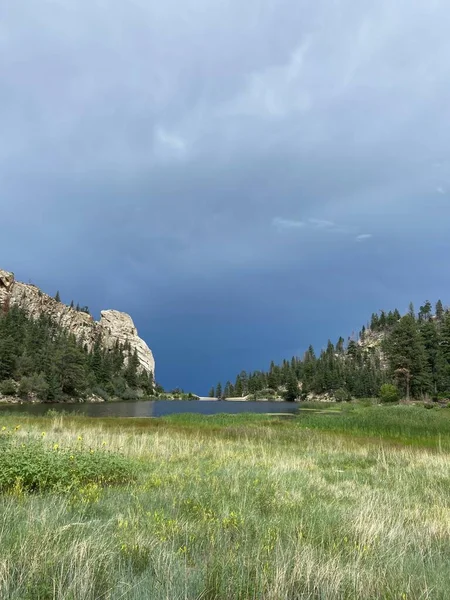 Bulutlu bir günde, her iki tarafında dağ sırtları olan bir rezervuar. Çiftlikteki en güzel yerlerden biri. 2022 Yaz sezonunda Philmont Scout Çiftliğinde çekildi.