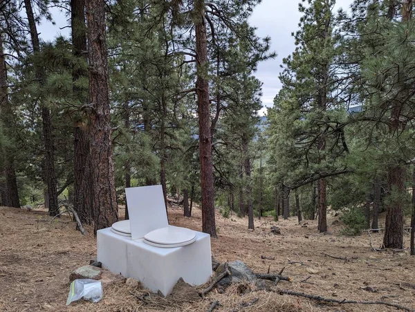 A photo of a latrine in the forest at Aguila Trail Camp. Taken at Philmont Scout Ranch during the 2022 Summer Season
