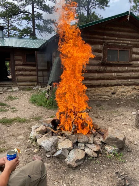 Gün boyunca bir kulübenin önünde büyük bir kamp ateşi. 2022 Yaz sezonunda Philmont Scout Çiftliğinde çekildi.