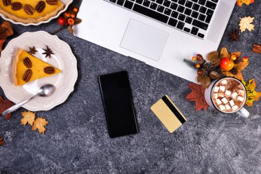 Çalışma alanı dizüstü bilgisayar, sıcak çikolata ve ev yapımı balkabağı turtası.