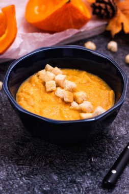 Bir kase kabak çorbası, kızarmış ekmek ve çekirdekli.