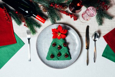 Seramik bulaşık takımı ve gümüş sofra takımı ile Noel sofrası.