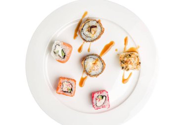 Beyaz arka planda izole edilmiş tabak üzerindeki suşi ruloları