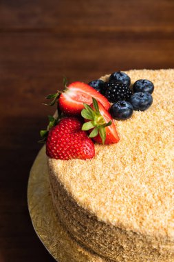 Çilek ve yaban mersinli ballı pasta. Geleneksel Rus tatlıları ahşap masada.