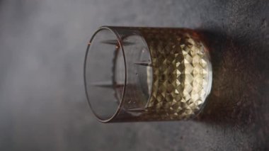 Viski bardağına su dökmek. Gün batımı ışığı barın üzerinde. Dikey video