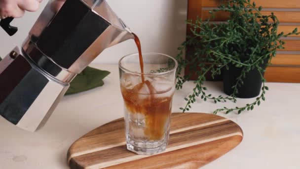 Espresso Uit Moka Pot Een Glas Met Tonic Ijsblokjes Gieten — Stockvideo