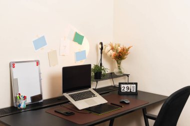 Rahat ve rahat ev ofisin siyah masasında dizüstü bilgisayarı var. Öğrenci yatak odası iç çalışma alanı. Model ekran