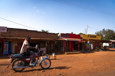 Afrikalı motosikletçiler dükkan boyunca yol kenarına gidiyor..