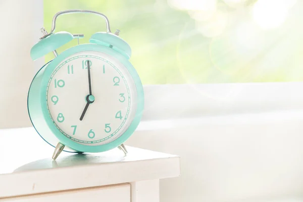 Circadian rytmer koncept - väckarklocka inställd på 7 am med solstrålar — Stockfoto