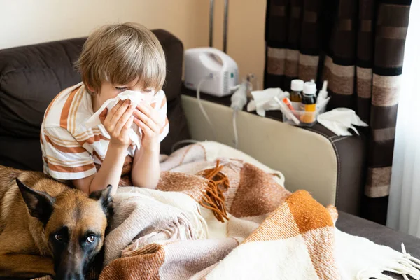 Sick child on the sofa at home with pet. Healthcare concept