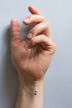 Depresyon ve akıl sağlığı konsepti. Bileğindeki noktalı virgül dövmesi. Yüksek kalite fotoğraf