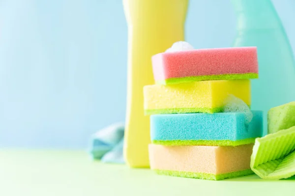 Cleaning concept - cleaning supplies on pastel yellow background, copy space