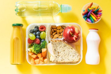 Back to school concept - school lunch with colorful pensils on yellow background. High quality photo