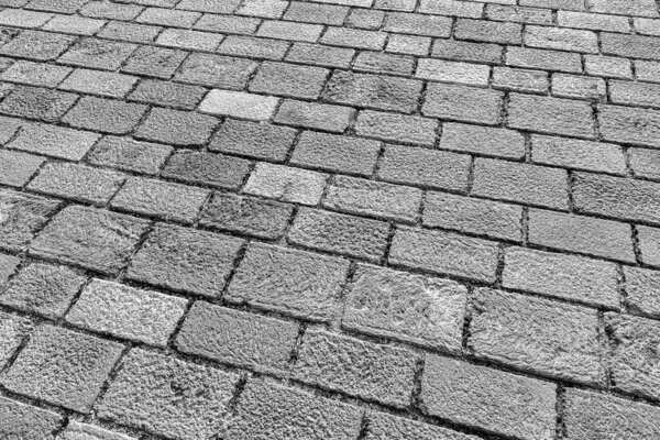 Black and white old cobblestone pavement texture. Ancient sidewalk background.