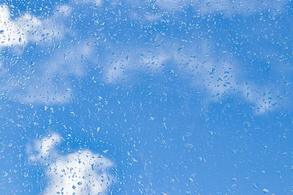 雨滴落在窗玻璃表面 蓝天和云彩背景 雨滴的自然背景 由雨天转为晴天的概念 — 图库照片
