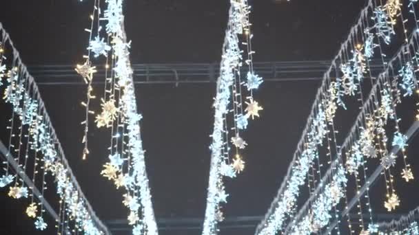 Las guirnaldas de fiesta de Año Nuevo o de Navidad en forma de los copos de nieve por la noche. — Vídeos de Stock