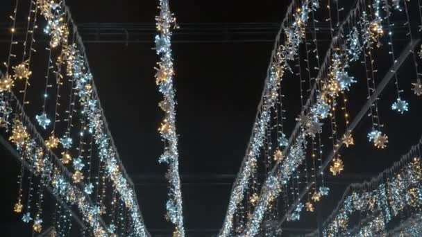 Las guirnaldas de fiesta de Año Nuevo o de Navidad en forma de los copos de nieve por la noche. — Vídeos de Stock