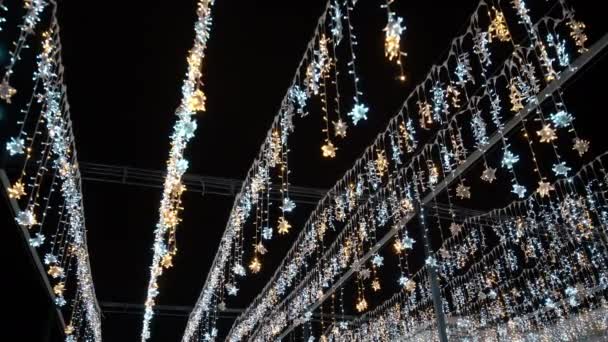 Festliche Neujahrs- oder Weihnachtsgirlanden in Form von Schneeflocken in der Nacht. — Stockvideo