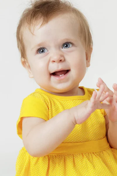 Hafif bir arka plan üzerinde sarı elbiseli küçük kız