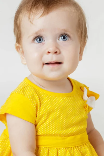 Hafif bir arka plan üzerinde sarı elbiseli küçük kız