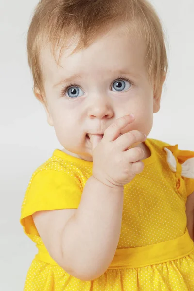 Hafif bir arka plan üzerinde sarı elbiseli küçük kız