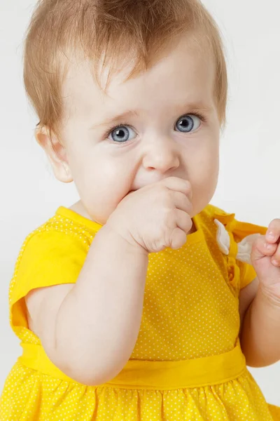 Hafif bir arka plan üzerinde sarı elbiseli küçük kız