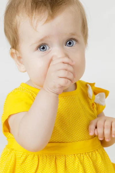 Hafif bir arka plan üzerinde sarı elbiseli küçük kız