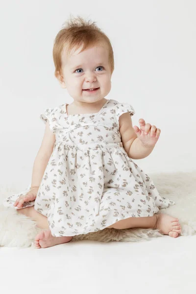 Hafif arka planda, hafif elbiseli küçük kız.