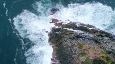 Su sıçratan ve beyaz köpüklü kayalıklara çarpan inanılmaz büyük dalgalar. Tayland 'ın Phuket Adası' ndaki deniz manzaralı güzel deniz manzaralı insansız hava aracı kamerasından yüksek kaliteli video.