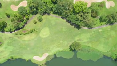 Tayland 'daki yeşil golf sahasının yukarısı. Golf sahasında yeşil çimenler ve ağaçlar var.