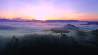 İnanılmaz sis denizi dağın üzerinden akar. Güneş doğar ya da batar. Sis manzaralı hava manzaralı İHA gökyüzü üzerinde uçar.