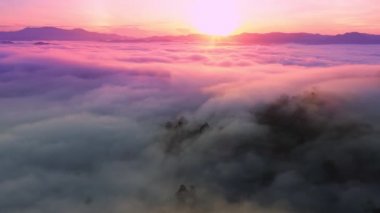 İnanılmaz sis denizi dağın üzerinden akar. Güneş doğar ya da batar. Sis manzaralı hava manzaralı İHA gökyüzü üzerinde uçar.