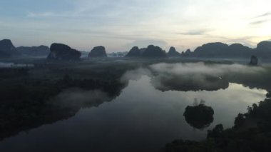 İnanılmaz sis denizi dağın üzerinden akar. Güneş doğar ya da batar. Sis manzaralı hava manzaralı İHA gökyüzü üzerinde uçar.