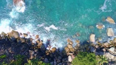 Dalgaların hava görüntüsü kayalara çarpıyor mavi okyanus dalgaları güzel deniz manzaralı insansız hava aracı 4k 'ye çarpıyor inanılmaz deniz manzarası insansız hava aracı kamerasından yüksek kaliteli görüntüler.