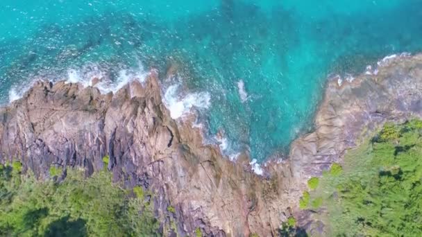 青い海の石の上に波が打ち寄せる空中からの眺め美しい海岸線に波が打ち寄せる空中からの眺めドローン4Kショット素晴らしい自然景観ドローンカメラからの高品質な映像 — ストック動画