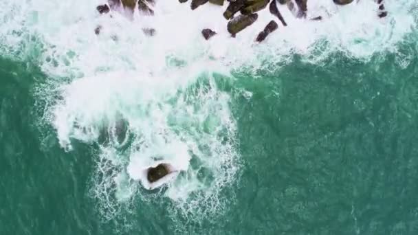 蓝海绿松石海面上海岸岩石的顶部俯瞰大海海浪冲击岩石海景空中景观无人机4K高质量的海洋岩石悬崖 — 图库视频影像