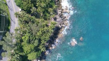 Mavi bir okyanustaki deniz kıyısı kayalarının tepesindeki drone kamerası Turkuaz deniz yüzeyindeki inanılmaz deniz dalgaları kayalara çarpıyor. Hava aracı 4K 'lık okyanus manzaralı, kaya kayalıkları olan 4K' lık yüksek kalite.