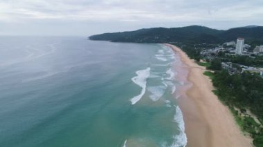Tropikal deniz kumlu sahili üzerinde uçan hava aracı görüntüsü ve Karon sahilindeki kumlu sahile vuran dalgalar Phuket Tayland