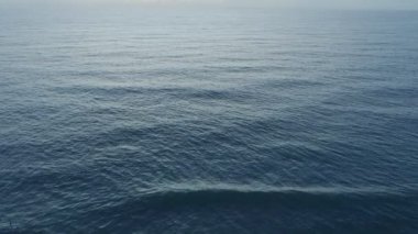 Yaz mevsiminde güzel deniz dalgaları İHA hava görüntülerinden inanılmaz okyanus yüzeyi arka planında uçan insansız hava aracı